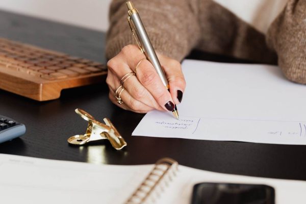 crop-elegant-business-lady-taking-notes-while-sitting-at-4491492.jpg